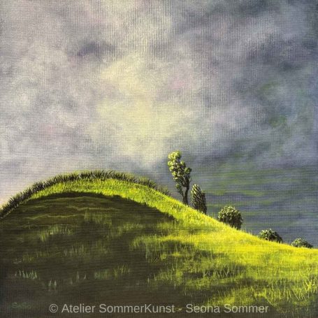 Grüne Hügel unter einem bewölkten Himmel, mit einzelnen Bäumen in der Landschaft.
