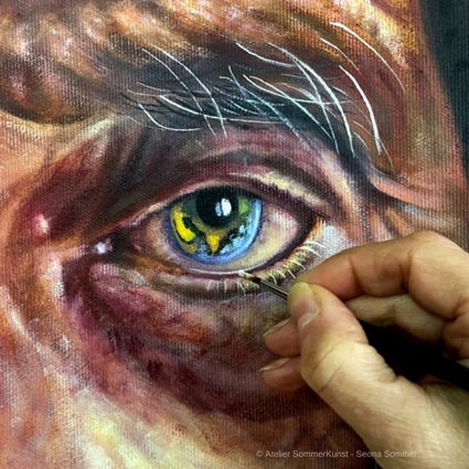Detailaufnahme der Künstlerin, die ein realistisches Auge malt.