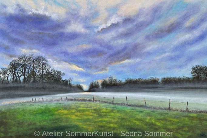 Landschaft mit grünen Wiesen, Bäumen im Hintergrund und dramatischem Himmel.